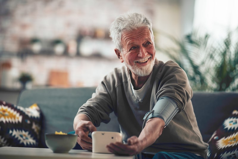 Senior-friendly devices Man taking his blood pressure at home